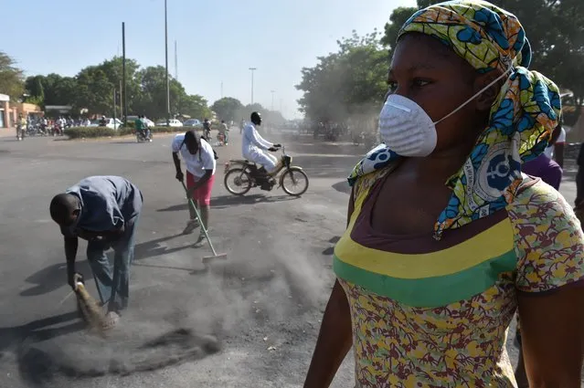 Inhabitants of Ouagadougou clean up the city on November 1, 2014. Rival military factions laid claim to power in Burkina Faso on Saturday after the west African nation's president fled following days of violent unrest over plans to extend his 27-year rule. (Photo by Issouf Sanogo/AFP Photo)