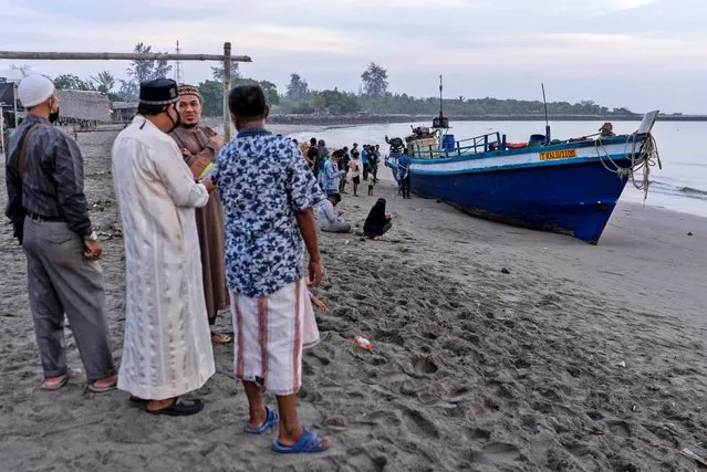 Local residents inspect the boat carrying hundreds of ethnic Rohingya people that landed on a beach in Lhokseumawe, Aceh province, Indonesia, Monday, September 7, 2020. Almost 300 Rohingya Muslims were found on a beach in Indonesia's Aceh province Monday and were evacuated by military, police and Red Cross volunteers, authorities said. (Photo by Zik Maulana/AP Photo)
