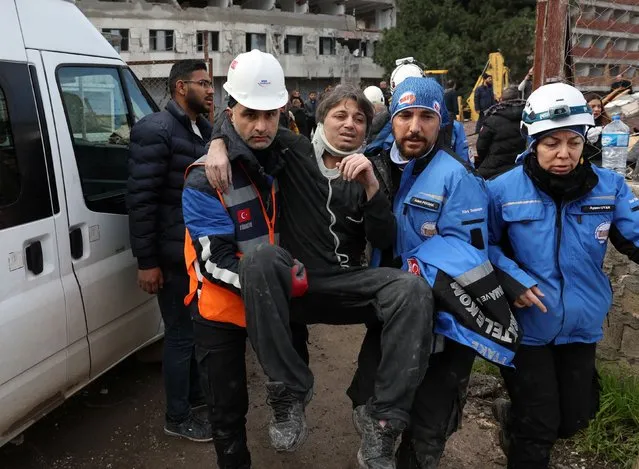 Gokhan Kinay is assisted by rescuers out of a damaged building, following an earthquake in Hatay, Turkey, February 7, 2023. (Photo by Umit Bektas/Reuters)