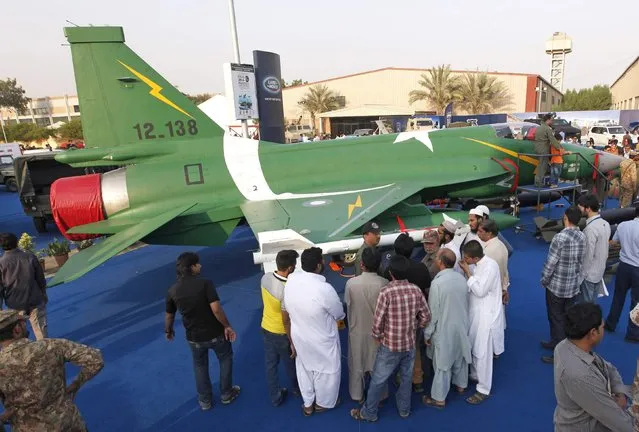 Visitors stand next to a JF-17 Thunder fighter jet during the last day of the International Defence Exhibition and Seminar “IDEAS 2014” in Karachi December 4, 2014. At least 88 delegations from 47 countries took part at the 8th biennial IDEAS 2014 at the Karachi Expo Centre, local media reported. (Photo by Akhtar Soomro/Reuters)