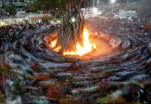 Hindu devotees walk around a bonfire during a ritual known as “Holika Dahan” which is part of the Holi festival celebrations on the outskirts of Ahmedabad, India on March 6, 2023. (Photo by Amit Dave/Reuters)