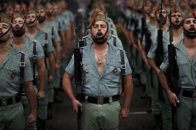 Members of La Legion, an elite unit of the Spanish Army, sing during a military parade as they celebrate a holiday known as “Dia de la Hispanidad” or Hispanic Day in Madrid, Wednesday, October 12, 2016. Almost a year into Spain's political deadlock, the country is celebrating its National Day with a military parade of over 3,000 soldiers marching through Madrid and aircraft drawing trails of red and yellow smoke in the sky to represent the flag. (Photo by Daniel Ochoa de Olza/AP Photo)
