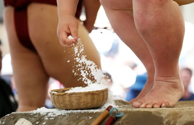 A sumo wrestler grabs salt before competing during an annual sumo tournament dedicated to the Yasukuni Shrine in Tokyo, Japan on April 16, 2018. (Photo by Toru Hanai/Reuters)