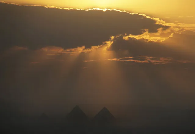 The sun hides behind clouds over the historical site of the Giza Pyramids located just outside Cairo, Egypt, Friday, October 30, 2015. (Photo by Amr Nabil/AP Photo)