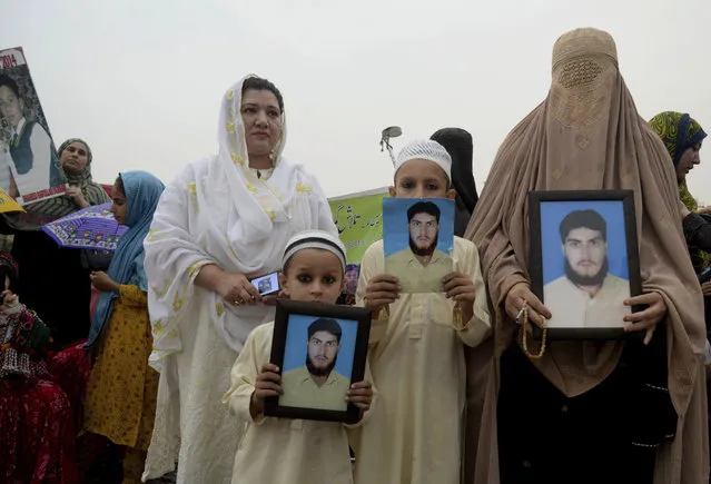 In this Sunday, April 8, 2018 file photo, a Pashtun family from a Pakistani tribal area display pictures of a missing family member during a Pashtun Protection Movement rally in Peshawar, Pakistan. A Pakistani rights group in the country's troubled border region has been protesting police brutality, censorship and disappearances, drawing a police campaign against its members and deepening tensions. (Photo by Muhammad Sajjad/AP Photo)