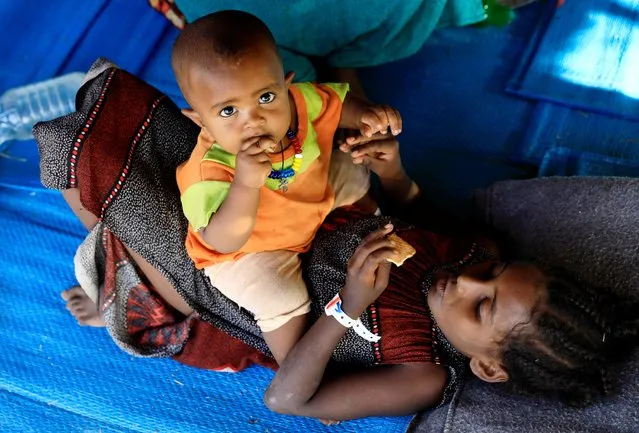 An Ethiopian woman who fled war in Tigray region, is seen with her child inside a makeshift shelter at the Um-Rakoba camp on the Sudan-Ethiopia border in Al-Qadarif state, Sudan on November 19, 2020. (Photo by Mohamed Nureldin Abdallah/Reuters)