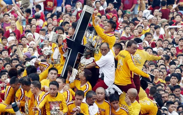 Devotees try to hold the Black Nazarene as it is pulled on a carriage during an annual procession in Manila, January 9, 2015. (Photo by Erik De Castro/Reuters)