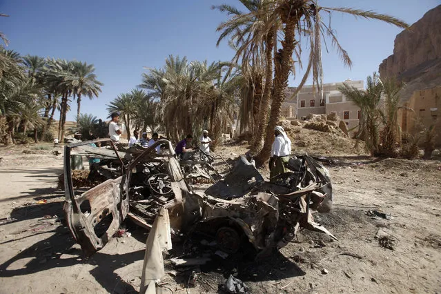 People gather near the wreckage of a car destroyed by a U.S. drone air strike that targeted suspected al Qaeda militants in August 2012, in the al-Qatn district of the southeastern Yemeni province of Hadhramout February 5, 2013. (Photo by Khaled Abdullah/Reuters)