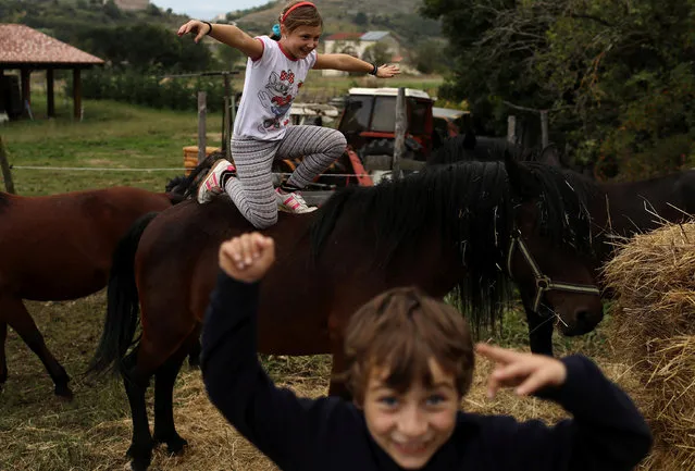 Ginevra, 10, and her brother Giulio Cesare, 7, play with their horses at the family farm in the town of Santo Stefano di Sessanio in the province of L'Aquila in Abruzzo, inside the national park of the Gran Sasso e Monti della Laga, Italy, September 13, 2016. (Photo by Siegfried Modola/Reuters)