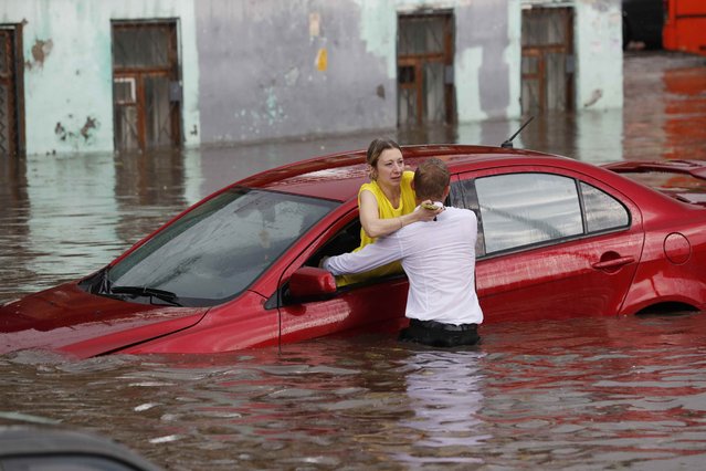 A woman is rescued from her flooded car at the street in Nizhny Novgorod, Russia on June 19, 2018. (Photo by Murad Sezer/Reuters)