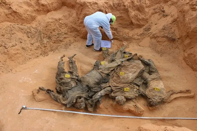 Bodies are pictured during the exhumation by members of the Government of National Accord's (GNA's) missing persons bureau, in what Libya's internationally recognized government officials say is a mass grave, in Tarhouna city, Libya on October 27, 2020. (Photo by Ayman Al-Sahili/Reuters)