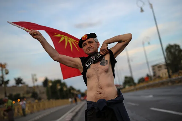 A supporter of opposition party VMRO-DPMNE waves a flag and shows his tattoo as he takes part in a protest over compromise solution in Macedonia's dispute with Greece over the country's name, in Skopje, Macedonia, June 2, 2018. (Photo by Marko Djurica/Reuters)
