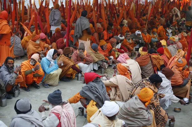 Indian Sadhus, or Hindu holy men, participate in a community feast at the Sangam, the confluence of the Rivers Ganges, Yamuna and mythical Saraswati, during the annual month-long Magh Mela religious fair in Allahabad, India, Friday, January 16, 2015. Hundreds of thousands of devout Hindus are expected to take holy dips at the confluence during the astronomically auspicious period of over 45 days celebrated as Magh Mela. (Photo by Rajesh Kumar Singh/AP Photo)