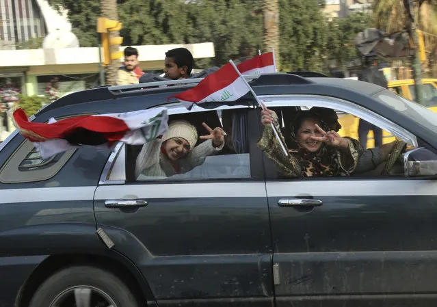 Iraqi soccer fans wave their country's flag after their national team beat Iran in their Asian Cup quarterfinal as the fans watch the match on TV in Baghdad, Iraq, Friday, January 23, 2015. Iraq outlasted a short-handed Iran in penalty shootouts to end thrilling Asian Cup quarterfinals on Friday. (Photo by Hadi Mizban/AP Photo)