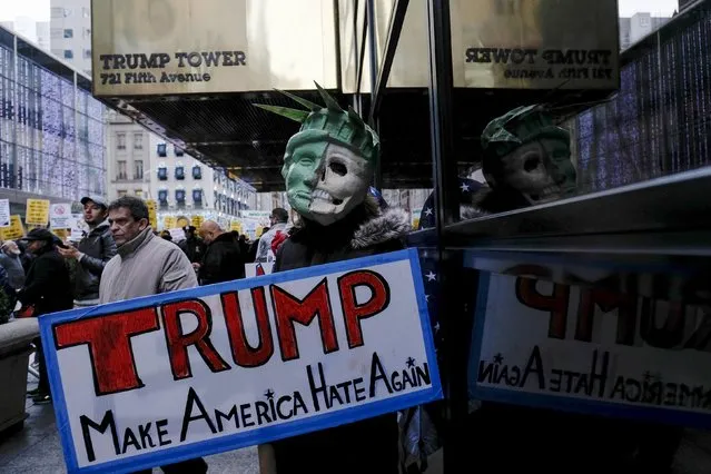 A woman half-dressed as the Statue of Liberty holds a banner to protest against U.S. Republican presidential candidate Donald Trump, outside of his office in Manhattan, New York, December 20, 2015. (Photo by Eduardo Munoz/Reuters)