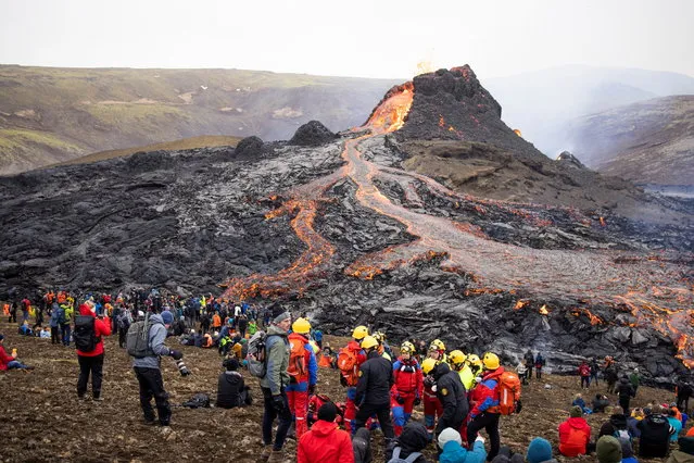 People gather at the volcanic site on the Reykjanes Peninsula following Friday's eruption in Iceland, March 21, 2021. (Photo by Cat Gundry-Beck/Reuters)