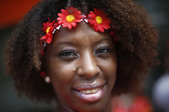 A woman poses for a photo during a street party promoting black pride and  encouraging Afro-Brazilian women to flaunt their curls in Rio de Janeiro, Brazil, Sunday, February 8, 2015. The party was sponsored by a beauty salon that encourages Afro-Brazilian women to enjoy their natural hair and resist social pressures to straighten it. (Photo by Silvia Izquierdo/AP Photo)