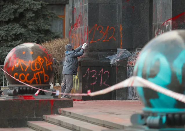 Workers try to clean graffiti on a wall at the Presidential office in Kiev, Ukraine, 24 March 2021. Protestors left graffiti at the site on 20 March 2021 during a mass rally to support all pro-Ukrainian persecuted activists and marking the birthday of Serhiy Sternenko, a jailed Ukrainian nationalist activist. (Photo by Sergey Dolzhenko/EPA/EFE)