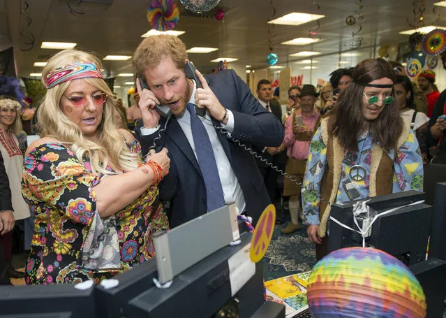 Britain's Prince Harry, centre, talks on the phone, during an ICAP Charity Trading Day in support of Sentebale – a charity supporting orphans and vulnerable children, with Amanda Hartnell, left and Dermot Doherty, in London, Wednesday, December 7, 2016. (Photo by Geoff Pugh/Pool Photo via AP Photo)