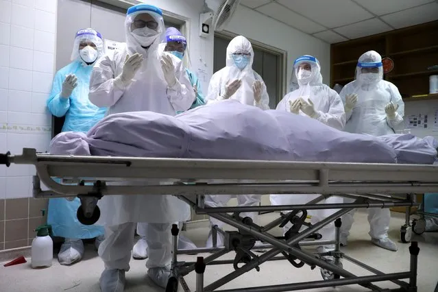 Family members of a victim of the coronavirus disease (COVID-19) pray at a hospital mortuary before burial, in Kuala Lumpur, Malaysia on May 23, 2021. (Photo by Lim Huey Teng/Reuters)