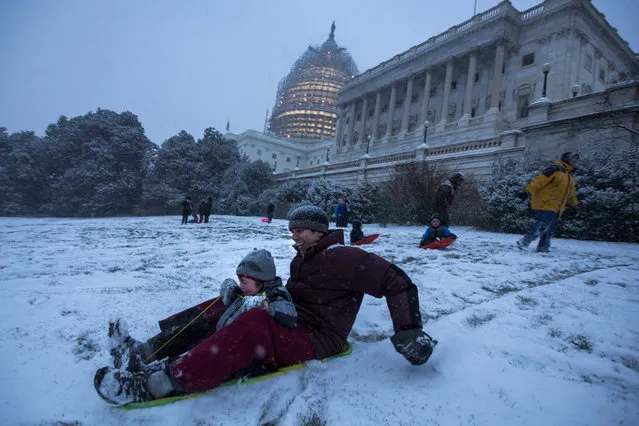 People sled down a small hill by the U.S. Capitol as the first snow from a major blizzard hits Washington, DC, USA, 22 January 2016. Winter Storm Jonas is expected to dump more than two feet (61 centimeters) of snow in the Washington, DC region throughout the weekend. (Photo by Jim Lo Scalzo/EPA)