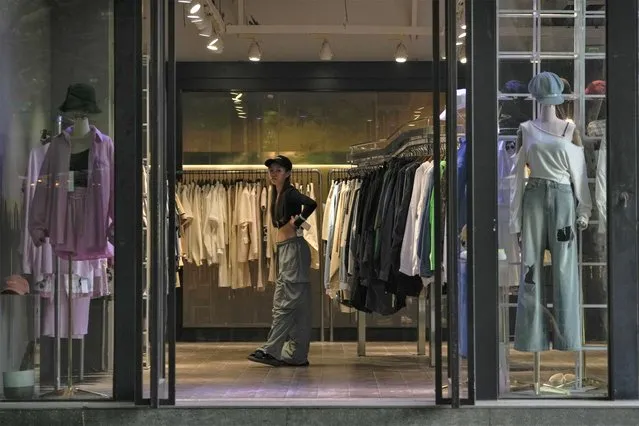 A worker tries out the clothing at a quiet fashion boutique in Beijing on Thursday, July 27, 2023.  Chinese leader Xi Jinping’s government is promising to drag the economy out of a crisis of confidence aggravated by tensions with Washington, wilting exports, job losses and anxiety among foreign companies about an expanded anti-spying law. (Photo by Andy Wong/AP Photo)