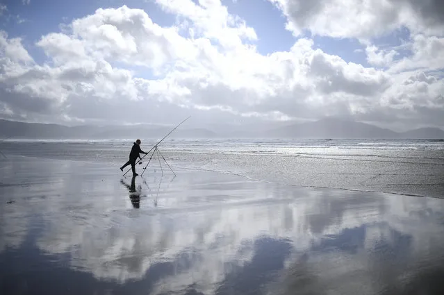 A man participates in the Diawa Irish Pairs sea angling event in windy conditions on the Dingle Peninsula of Inch beach in Inch, Ireland, September 18, 2018. (Photo by Clodagh Kilcoyne/Reuters)