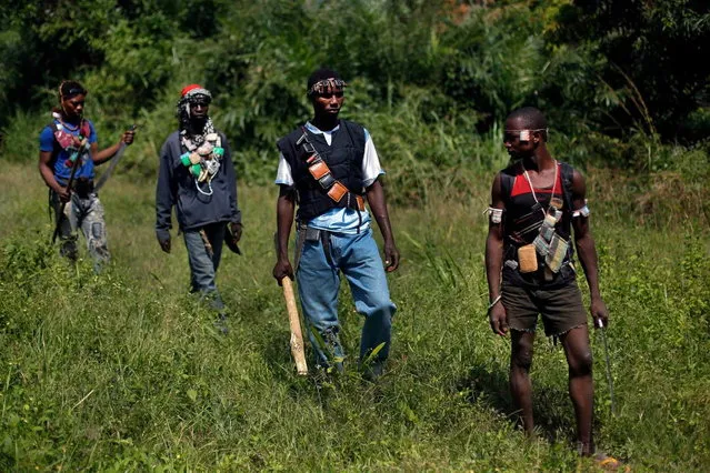 Anti-Balaka Christian militiamen walk through a forest clearing outside Central African Republic's capital Bangui Sunday December 15, 2013. (Photo by Jerome Delay/AP Photo)