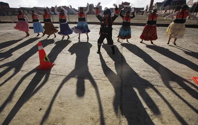In this November 28, 2013 photo, so-called “traffic cholitas” perform jumping jacks during a training session in El Alto, Bolivia. (Photo by Juan Karita/AP Photo)