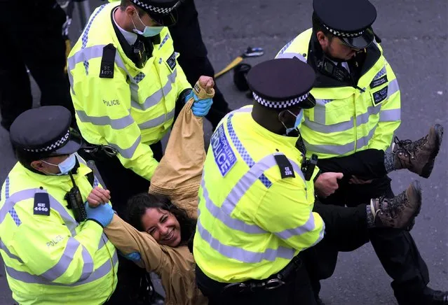 Police officers remove an Extinction Rebellion climate demonstrator from the roadblock by Tower Bridge during a protest in London, Britain, August 30, 2021. (Photo by Tom Nicholson/Reuters)