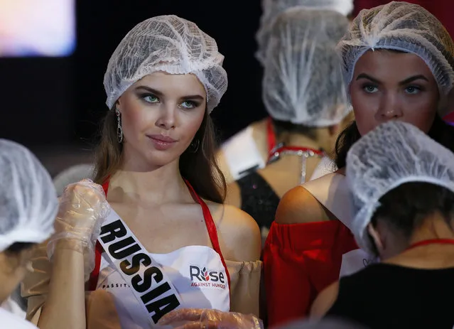 Miss Universe contestants Yuliana Korolkova of Russia adjusts her sash as she helps in packing meals for the needy in suburban Pasay city southeast of Manila, Philippines Wednesday, January 18, 2017. Eighty-six candidates from around the world are vying for the title to succeed Pia Wurtzbach from the Philippines. The competition takes place on Jan. 30. (Photo by Bullit Marquez/AP Photo)