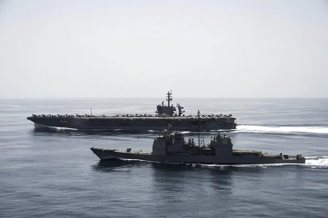 The aircraft carrier USS Theodore Roosevelt (CVN 71) and the guided-missile cruiser USS Normandy (CG 60) operate in the Arabian Sea conducting maritime security operations in this U.S. Navy photo taken April 21, 2015. (Photo by Mass Communication Specialist 3rd Class Anthony N. Hilkowski/Reuters/U.S. Navy)