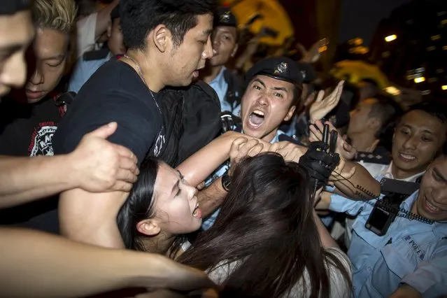 Policemen confront pro-democracy protesters (L) as they try to approach Chief Executive Leung Chun-ying's  vehicle during his public visit to appeal support on the government's political reform proposal in Hong Kong April 22, 2015. (Photo by Tyrone Siu/Reuters)
