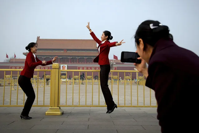 Hospitality staff jump as they pose for their colleague on Tiananmen Square during the opening session of the Chinese People's Political Consultative Conference (CPPCC) held at the Great Hall of the People in Beijing, Sunday, March 3, 2019. (Photo by Andy Wong/AP Photo)