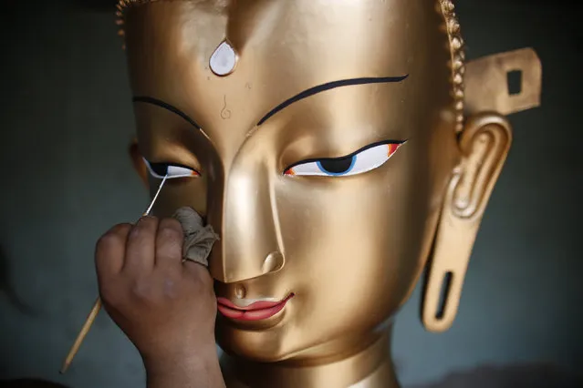 Saroj Shakya, 26, gives a finishing touch to the idol of Buddha ahead of the Samyak festival in Lalitpur, Nepal, March 11, 2016. (Photo by Navesh Chitrakar/Reuters)