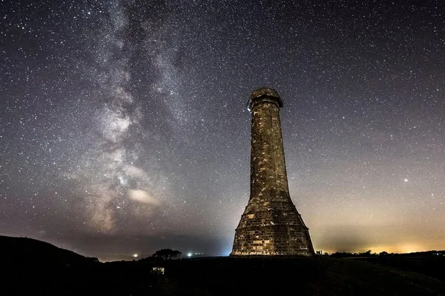 The Milky Way glows brightly in the clear night sky above Hardy Monument at Portesham in Dorset, United Kingdom on September 6, 2021. (Photo by Graham Hunt/Alamy Live News)