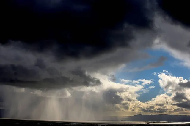 Storm clouds and rain move across the San Francisco Bay, Tuesday, April 7, 2015, in Hayward, Calif. (Photo by Aric Crabb/AP Photo/Bay Area News Group)