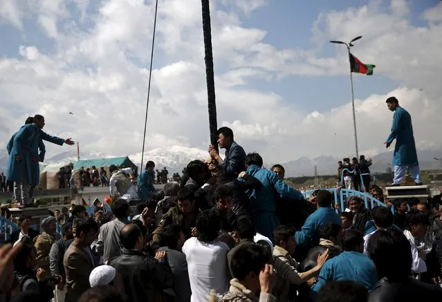 Afghans try to touch and kiss a religious flag to celebrate the Afghan New Year (Newroz) in Kabul, Afghanistan March 20, 2016. Afghanistan uses the Persian calendar which runs from the vernal equinox. The calendar takes as its start date the time when the Prophet Mohammad moved from Mecca to Medina in 621 AD. The current Persian year is 1395. (Photo by Ahmad Masood/Reuters)
