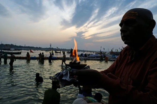 A Hindu devotee performs rituals at Sangam, the confluence of rivers the Ganges and the Yamuna during Maghi Purnima or the full-moon day at the annual traditional fair in Prayagraj, in the northern state of Uttar Pradesh, India, Saturday, February 24, 2024. Hundreds of thousands of Hindu pilgrims take dips here hoping to wash away sins during a month-long festival called Magh Mela. (Photo by Rajesh Kumar Singh/AP Photo)