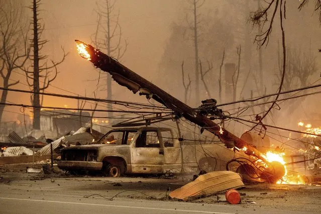 A utility pole burns as the Dixie Fire tears through the Greenville community of Plumas County, Calif., on Wednesday, August 4, 2021. The fire leveled multiple historic buildings and dozens of homes in central Greenville. (Photo by Noah Berger/AP Photo)