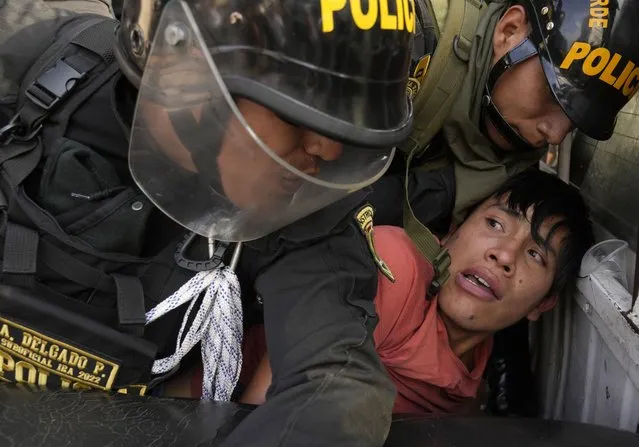 An anti-government protesters who traveled to the capital from across the country to march against Peruvian President Dina Boluarte, is detained and thrown on the back of police vehicle during clashes in Lima, Peru, Thursday, January 19, 2023. Protesters are seeking immediate elections, Boluarte's resignation, the release of ousted President Pedro Castillo and justice for up to 48 protesters killed in clashes with police. (Photo by Martin Mejia/AP Photo)