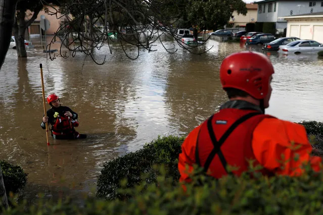 A firefighter with the San Jose Fire Department walks in a flooded neighborhood after heavy rains overflowed nearby Coyote Creek in San Jose, California, U.S., February 21, 2017. (Photo by Stephen Lam/Reuters)