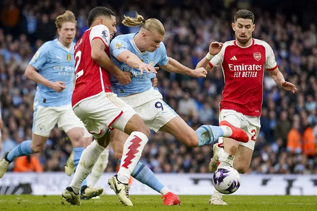 Manchester City's Erling Haaland, center right, duels for the ball with Arsenal's William Saliba during the English Premier League soccer match between Manchester City and Arsenal at the Etihad stadium in Manchester, England, Sunday, March 31, 2024. (Photo by Dave Thompson/AP Photo)