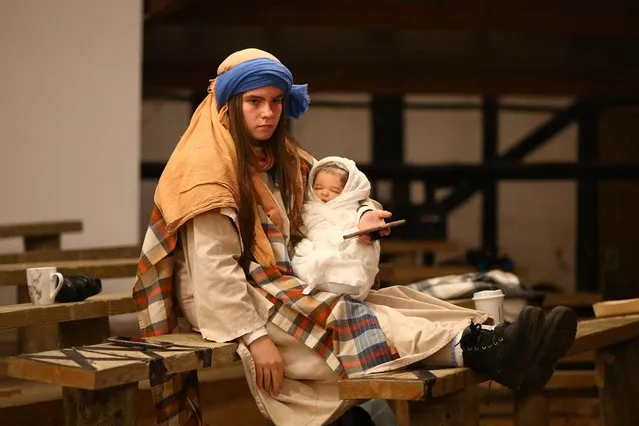 An actor holds a fake baby while waiting for the Wintershall Nativity play dress rehearsal to begin at Wintersall Estate on December 12, 2021 in Guildford, England. The Nativity play, which tells the story of the birth of Jesus Christ, has been performed annually since 1990 over the Christmas period by the Wintershall players. (Photo by Hollie Adams/Getty Images)