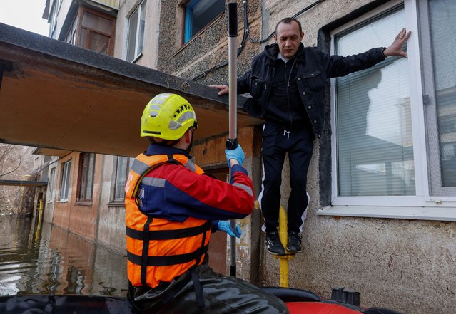 A man prepares to jump into rescuers' boat during evacuation amid flooding in Orsk, Orenburg region, Russia, on April 13, 2024. (Photo by Maxim Shemetov/Reuters)