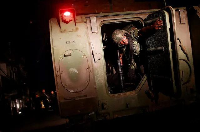 Brazilian Navy soldiers enter the unpacified Complexo da Mare, one of the largest “favela” complexes in Rio de Janeiro, on March 30, 2014. The government has deployed federal forces to occupy the group of violence-plagued slums ahead of the June 12 start of the 2014 FIFA World Cup. The group of 16 communities house around 130,000 residents and have been dominated by drug gangs and militias. (Photo by Mario Tama/Getty Images)