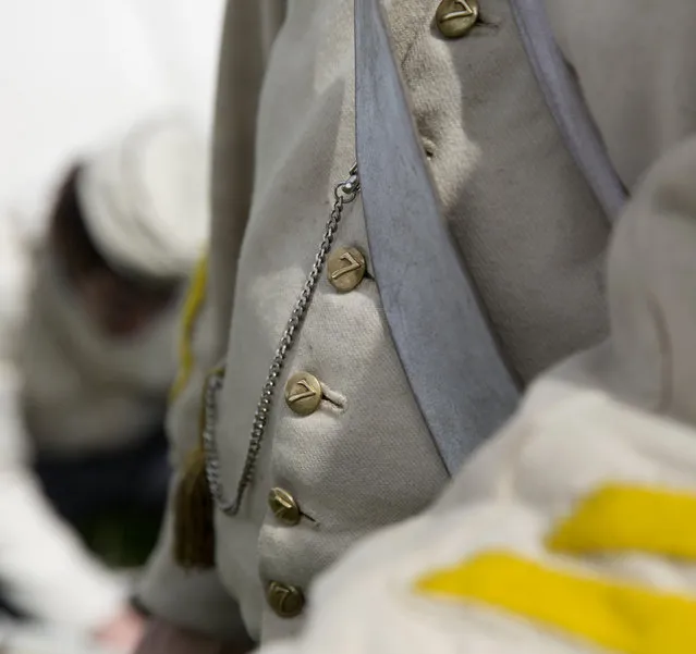In this May 9, 2015, photo, an historical re-enactor, dressed as a soldier of the Belgian-Dutch 7th Battalion of the Line, listens to instruction at a Napoleonic era living history camp in Elewijt, Belgium. Members of the Battle of Waterloo living history group spend more than 1500 euros each on replica uniforms, ordering their cloth from a source in the United Kingdom and hiring local seamstresses to follow a period pattern. (AP Photo/Virginia Mayo)
