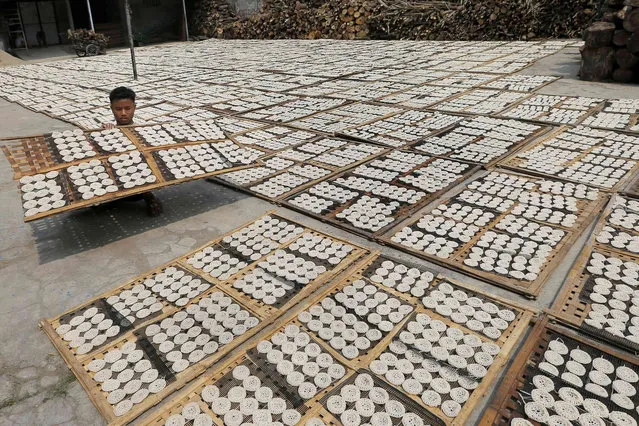 A worker dries crackers before frying at a home factory on the outskirts of Jakarta, Indonesia, Friday, June 21, 2019. (Photo by Tatan Syuflana/AP Photo)