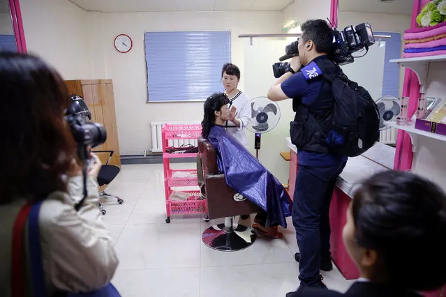 A woman is filmed having her hair done during a government organised visit for foreign reporters to the Pyongyang 326 Electric Cable Factory in Pyongyang, North Korea May 6, 2016. (Photo by Damir Sagolj/Reuters)