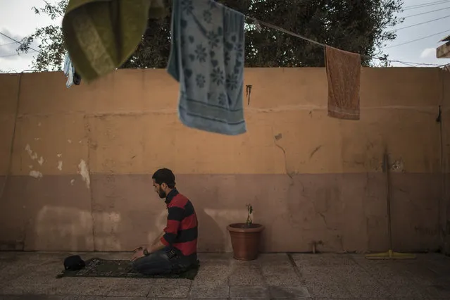 In this April 2, 2017 photo, Mahmoud Salem Ismail prays at his house in east Mosul, Iraq. He first found the body of his nephew, then as rescue workers pulled more and more bodies out of the pile of concrete that was once his sister’s home in western Mosul, it was too much for Mahmoud Salem Ismail. He collapsed next to the body bags on the ground. He lost 14 relatives in the March 17 strike that killed more than 100 people. He said the victims crowded into the building because it had a cellar and was seen as the safest place. (Photo by Felipe Dana/AP Photo)